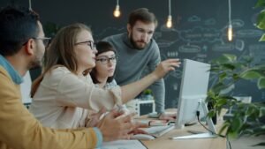 Équipe RH réunie autour d’un ordinateur pour expérimenter des usages professionnels de l’IA